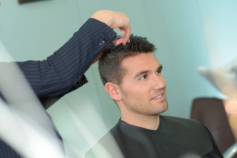 Giovane che ha taglio di capelli con le forbici immagine stock libera da diritti Giovane che ha taglio di capelli con le forbici immagine stock libera da diritti