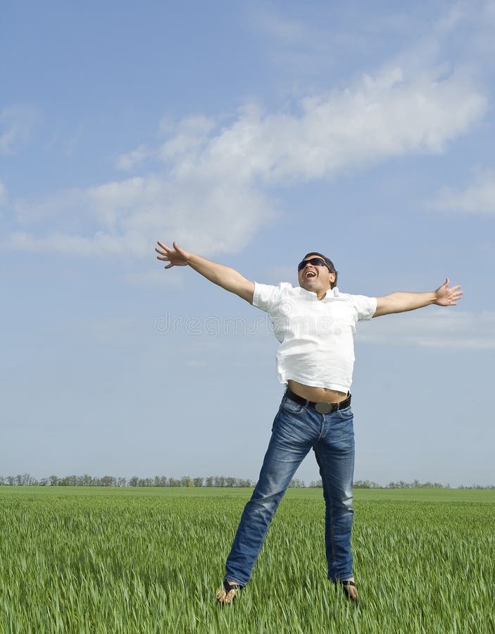 Giovane che salta un campo verde di erba fotografia stock libera da diritti Giovane che salta un campo verde di erba fotografia stock libera da diritti