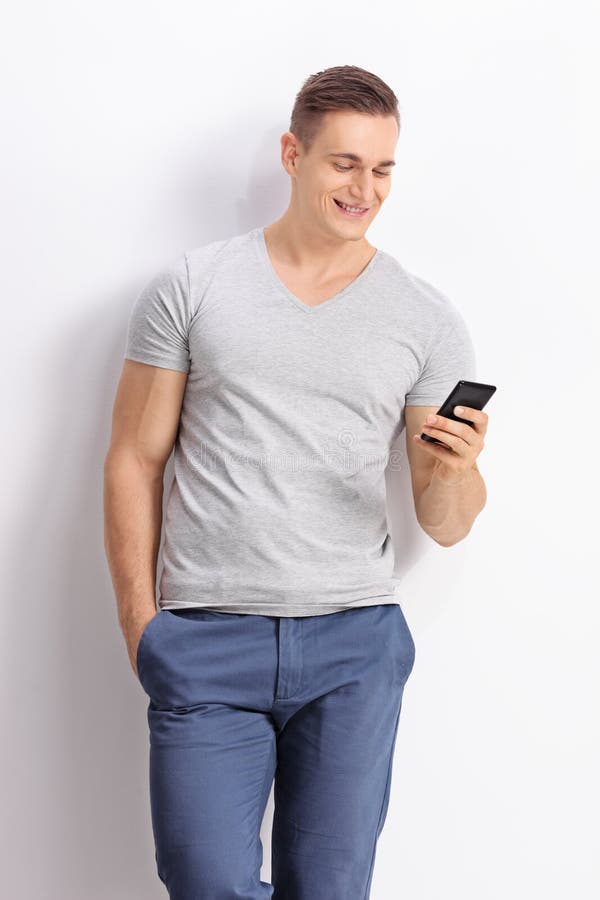 Giovane che scrive SMS a macchina sul suo telefono cellulare immagine stock libera da diritti Giovane che scrive SMS a macchina sul suo telefono cellulare immagine stock libera da diritti