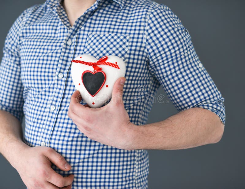 Giovane che tiene un cuore Giorno del biglietto di S fotografia stock libera da diritti Giovane che tiene un cuore Giorno del biglietto di S fotografia stock libera da diritti
