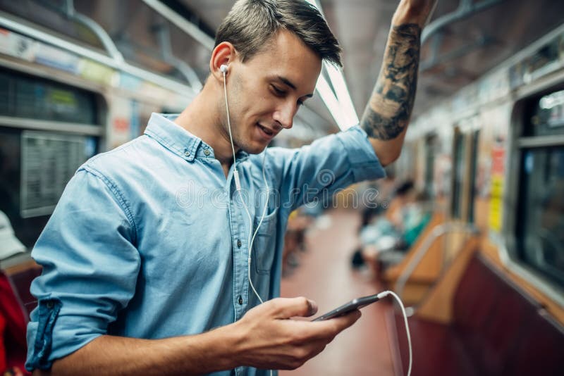 Young man using phone in metro, addiction problem, social addicted people, modern underground lifestyle. Young man using phone in metro, addiction problem, social addicted people, modern underground lifestyle