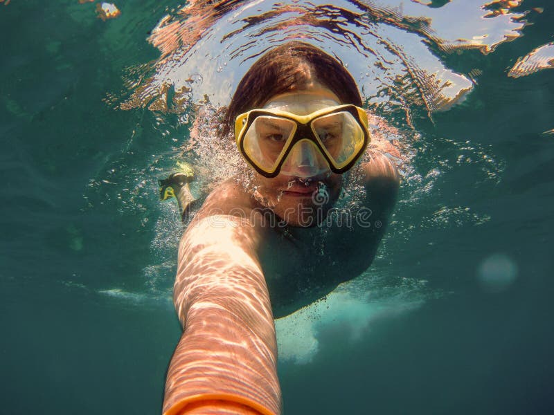 Giovane con la presa d'aria ed il nuoto d'immersione della maschera e la presa del selfie sotto l'acqua Concetto di viaggio, di v immagini stock libere da diritti Giovane con la presa d'aria ed il nuoto d'immersione della maschera e la presa del selfie sotto l'acqua Concetto di viaggio, di v immagini stock libere da diritti