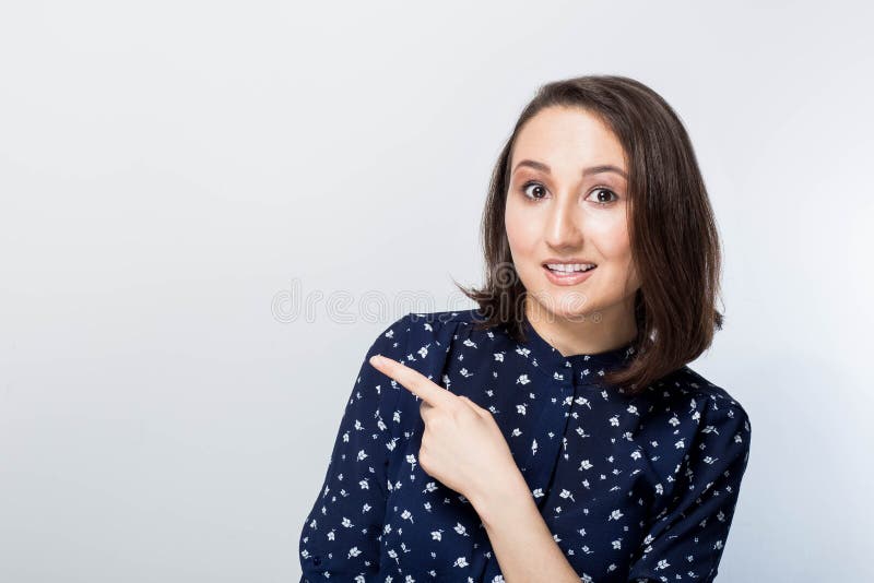 Giovane donna affascinante felice che mostra un dito e che indica su, fondo bianco Bella sorpresa della ragazza che mostra prodot immagini stock Giovane donna affascinante felice che mostra un dito e che indica su, fondo bianco Bella sorpresa della ragazza che mostra prodot immagini stock