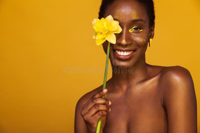 Giovane donna africana allegra con trucco giallo su lei occhi Risata di modello femminile contro il fondo giallo con giallo immagine stock Giovane donna africana allegra con trucco giallo su lei occhi Risata di modello femminile contro il fondo giallo con giallo immagine stock