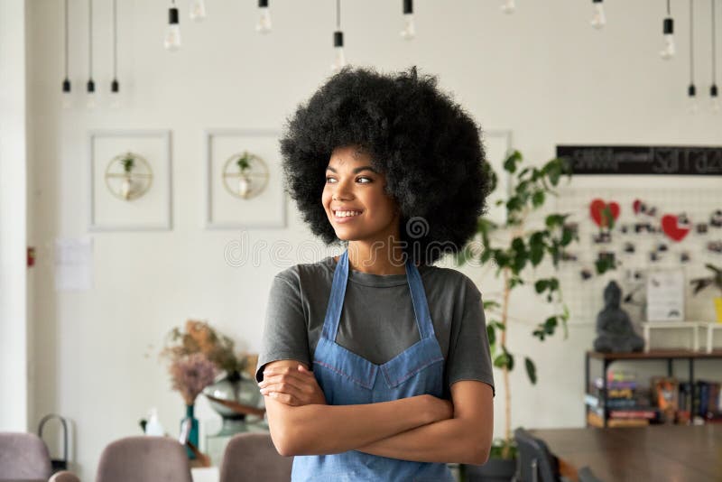 Giovane donna afro - cafè, giovane proprietaria di un piccolo business, si è incrociata tra le braccia. immagine stock libera da diritti