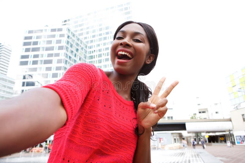 Giovane donna afroamericana allegra che prende selfie nella città immagini stock libere da diritti Giovane donna afroamericana allegra che prende selfie nella città immagini stock libere da diritti