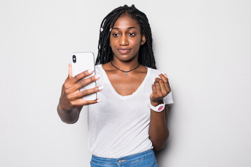 Giovane donna afroamericana che prende un selfie isolato su fondo grigio immagine stock Giovane donna afroamericana che prende un selfie isolato su fondo grigio immagine stock