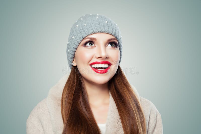 Giovane donna allegra in cappello grigio che cerca e che sorride fotografie stock libere da diritti Giovane donna allegra in cappello grigio che cerca e che sorride fotografie stock libere da diritti