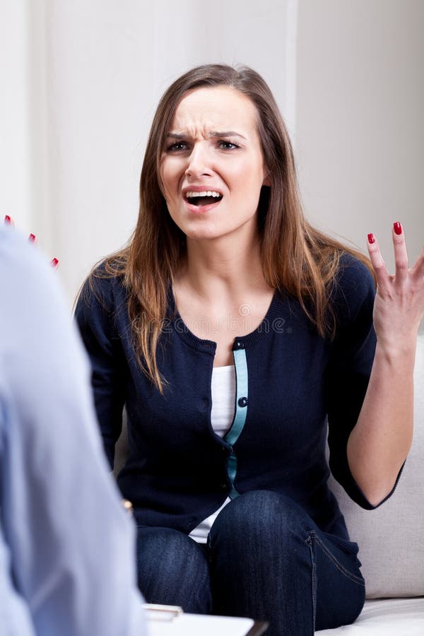 Giovane donna arrabbiata durante la psicoterapia immagini stock libere da diritti