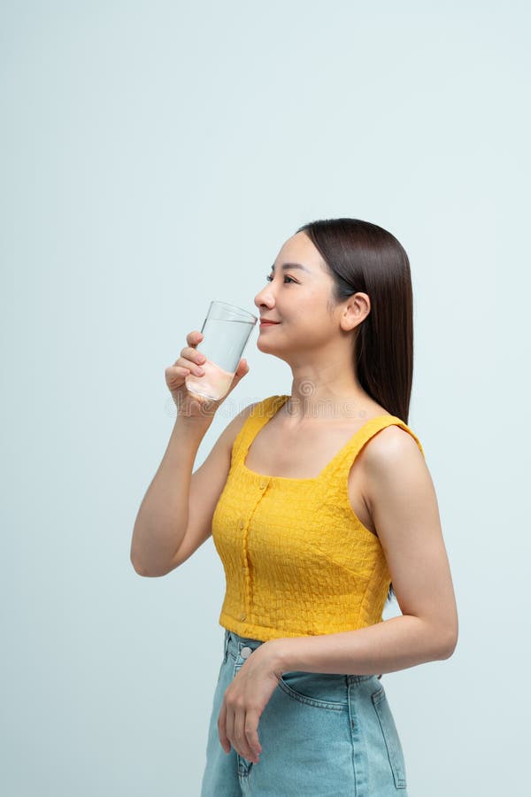 Giovane donna asiatica attraente che beve acqua fotografie stock