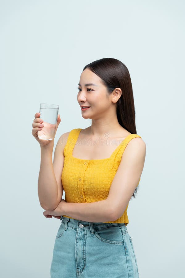Giovane donna asiatica attraente che beve acqua fotografie stock libere da diritti