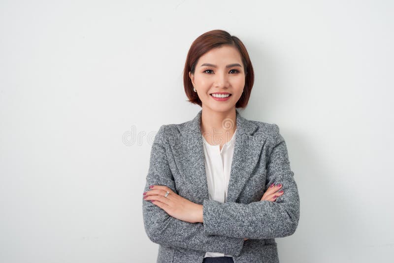 Giovane donna asiatica dell'imprenditore, armi della donna di affari attraversate su fondo bianco