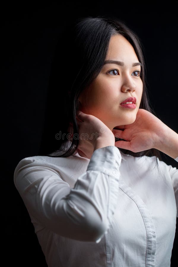 Giovane donna asiatica nel bianco sopra fondo nero Il nero e briciolo fotografia stock Giovane donna asiatica nel bianco sopra fondo nero Il nero e briciolo fotografia stock