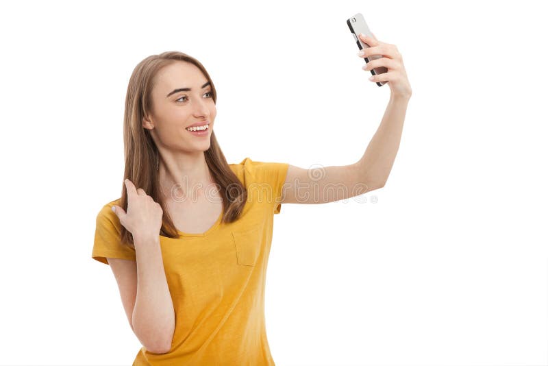 Giovane donna attraente del ritratto che fa la foto del selfie sullo smartphone isolato su un fondo bianco Derisione su immagine stock Giovane donna attraente del ritratto che fa la foto del selfie sullo smartphone isolato su un fondo bianco Derisione su immagine stock