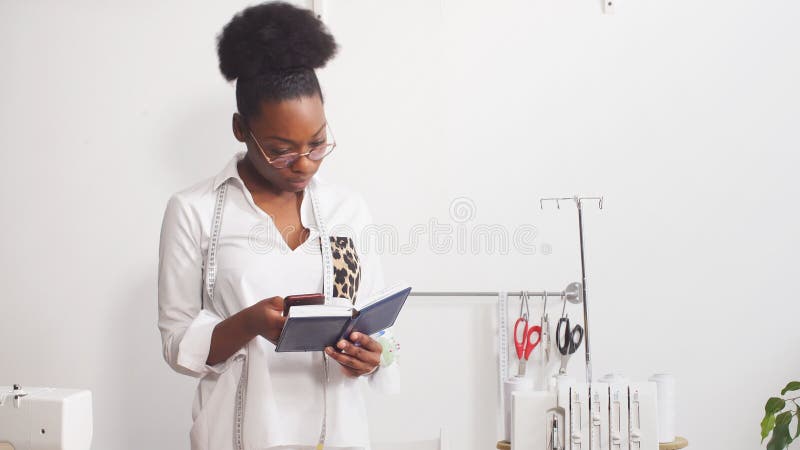 Giovane donna attraente dello stilista che lavora a casa studio