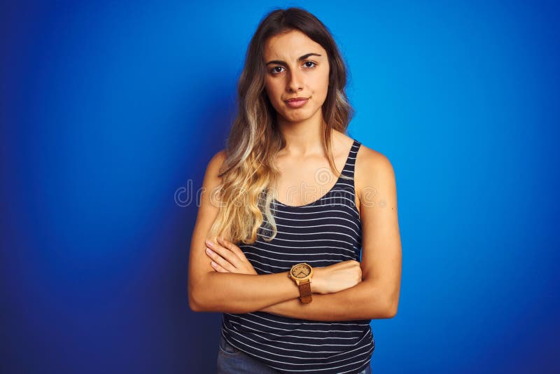 Giovane donna bella camicetta a strisce su sfondo blu scettico e nervoso che disapprova l'espressione sul viso fotografia stock libera da diritti