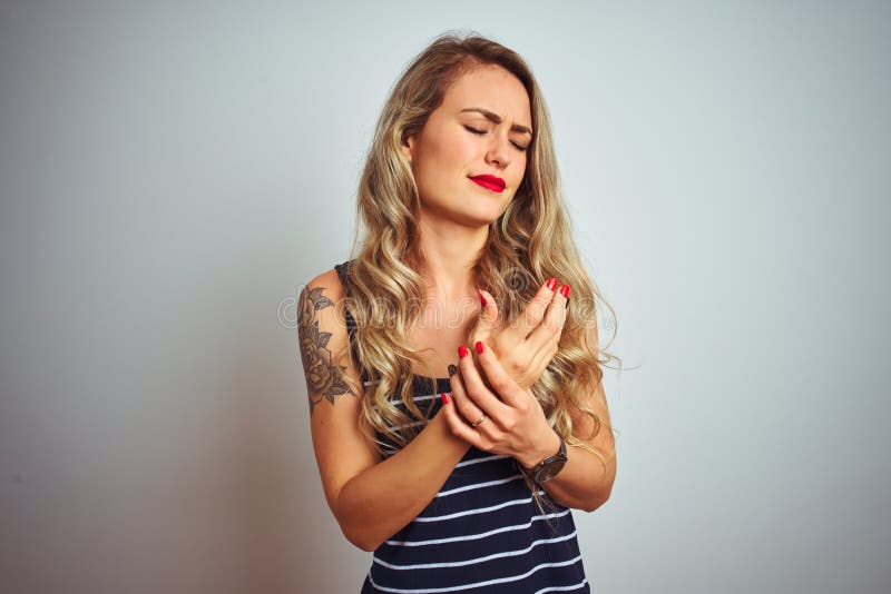 Giovane donna bella con una camicia in piedi sopra uno sfondo bianco isolato, dolorante alle mani e alle dita fotografie stock