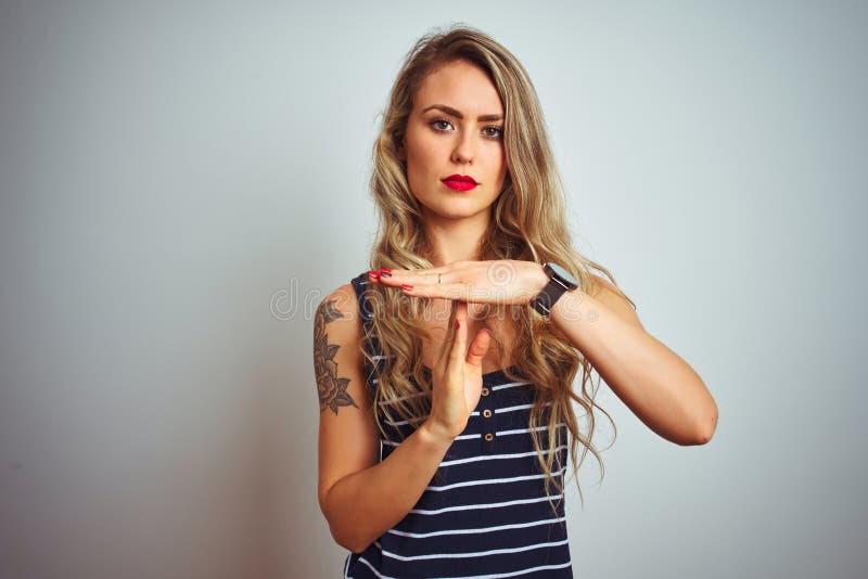 Giovane donna bella con una camicia a strisce in piedi su uno sfondo bianco isolato mentre compie un gesto con le mani immagini stock libere da diritti