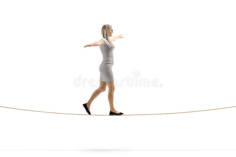 Giovane donna bionda che cammina su una corda con la diffusione di armi