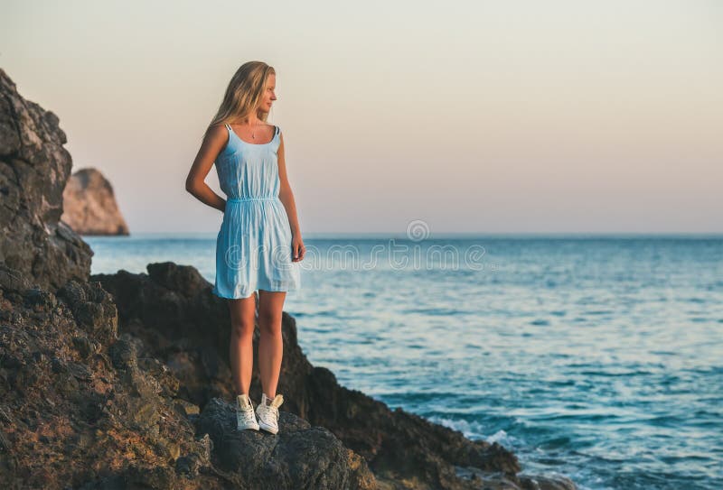 Giovane donna bionda che sta sulle rocce dal mare, Alanya, Turchia fotografia stock Giovane donna bionda che sta sulle rocce dal mare, Alanya, Turchia fotografia stock