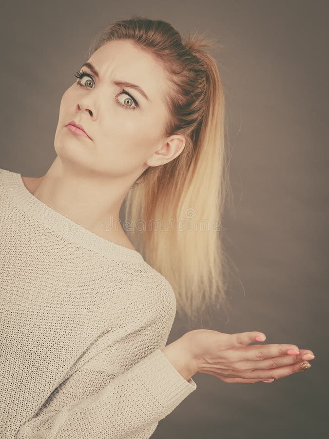 Giovane donna bionda confusa che gesturing con le mani fotografia stock libera da diritti Giovane donna bionda confusa che gesturing con le mani fotografia stock libera da diritti