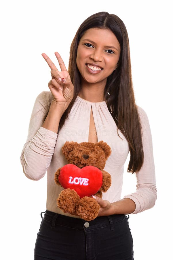 Giovane donna brasiliana felice che sorride mentre dà il segno di pace e immagini stock Giovane donna brasiliana felice che sorride mentre dà il segno di pace e immagini stock