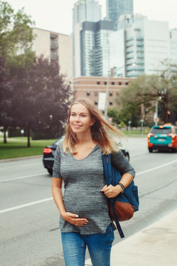Giovane donna caucasica bionda incinta che cammina nella città urbana occupata immagini stock Giovane donna caucasica bionda incinta che cammina nella città urbana occupata immagini stock