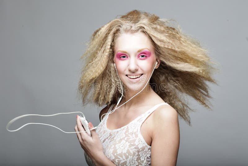Giovane donna che balla alla musica sulle sue cuffie fotografia stock Giovane donna che balla alla musica sulle sue cuffie fotografia stock