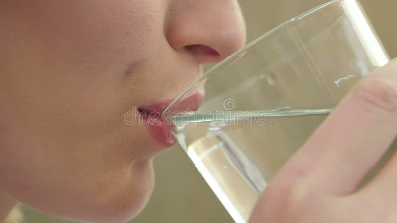 Giovane donna che beve acqua da un bicchiere