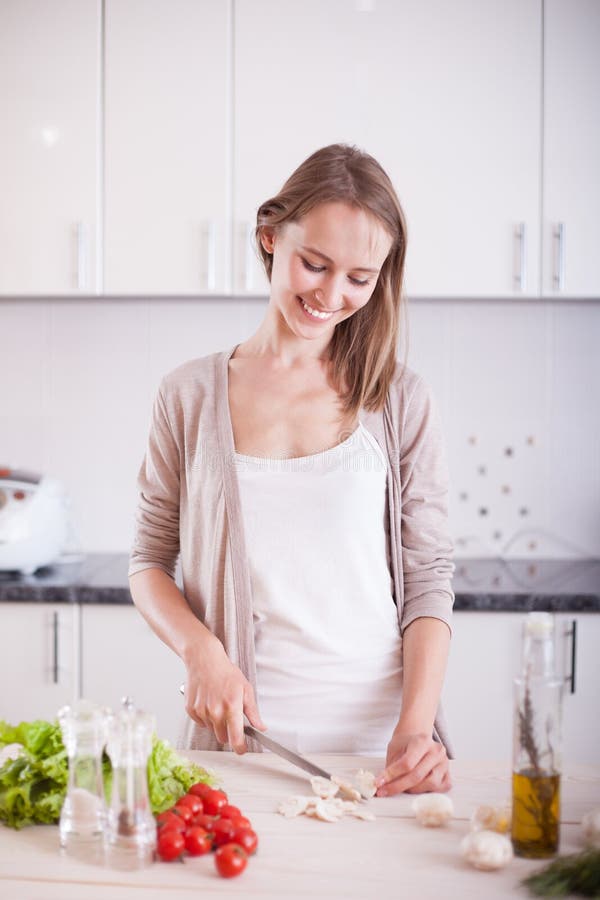 Young Woman Cooking in the kitchen. Dieting vegetarian concept. Healthy Lifestyle. Cooking At Home. Prepare Food. Young Woman Cooking in the kitchen. Dieting vegetarian concept. Healthy Lifestyle. Cooking At Home. Prepare Food