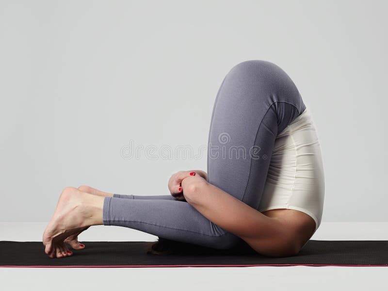Giovane donna che fa le esercitazioni di yoga ragazza in buona salute di sport fotografie stock libere da diritti Giovane donna che fa le esercitazioni di yoga ragazza in buona salute di sport fotografie stock libere da diritti