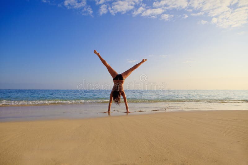 Giovane donna che fa un cartwhee fotografia stock Giovane donna che fa un cartwhee fotografia stock