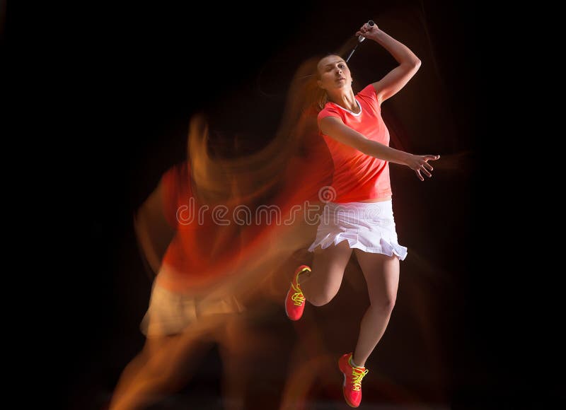 Giovane donna che gioca volano sopra fondo nero fotografia stock libera da diritti Giovane donna che gioca volano sopra fondo nero fotografia stock libera da diritti