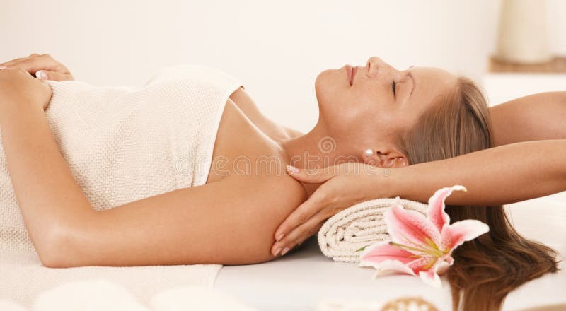 Giovane donna che gode del massaggio del collo fotografia stock libera da diritti Giovane donna che gode del massaggio del collo fotografia stock libera da diritti