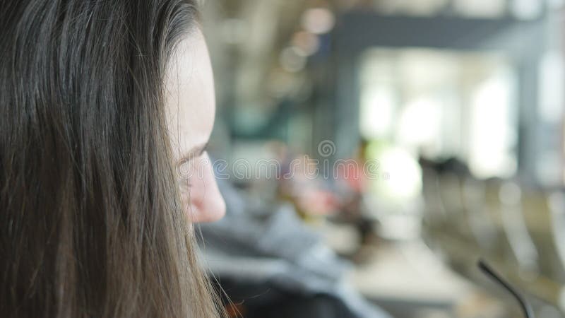 Giovane donna che guarda nello specchio e che corregge i suoi capelli Fine di cura di capelli su