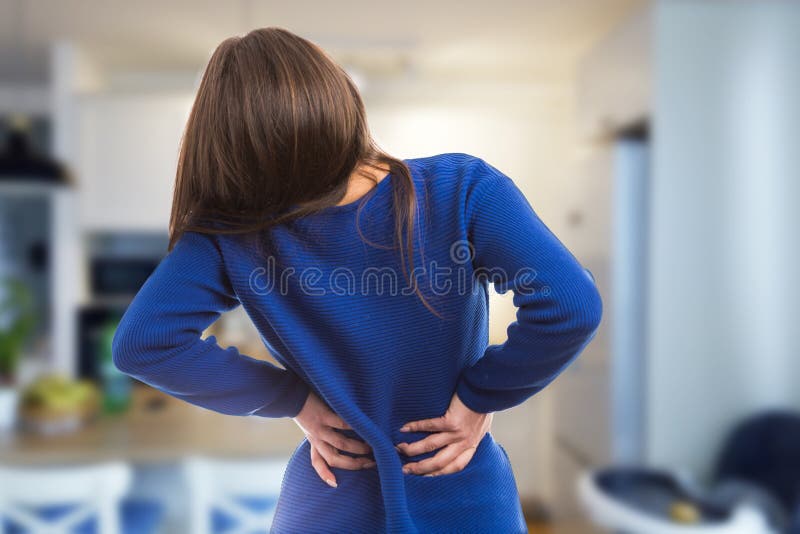 Giovane donna che ha dolore posteriore di sofferenza immagine stock libera da diritti Giovane donna che ha dolore posteriore di sofferenza immagine stock libera da diritti