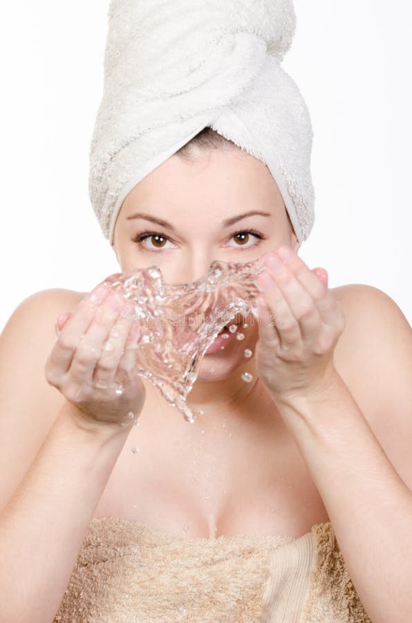 Young woman washing her face with water isolated. Young woman washing her face with water isolated