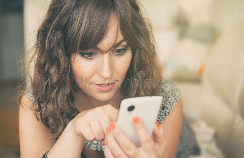 Giovane donna che manda un sms sul suo telefono cellulare fotografie stock libere da diritti Giovane donna che manda un sms sul suo telefono cellulare fotografie stock libere da diritti