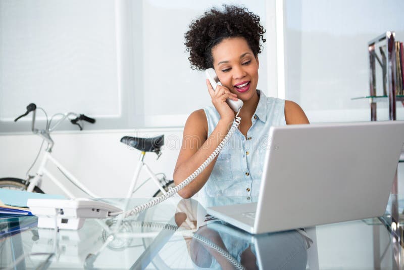 Giovane donna che per mezzo del telefono e del computer portatile fotografie stock libere da diritti Giovane donna che per mezzo del telefono e del computer portatile fotografie stock libere da diritti