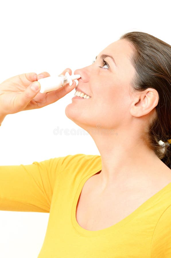 Young woman using nasal spray with white background. Young woman using nasal spray with white background