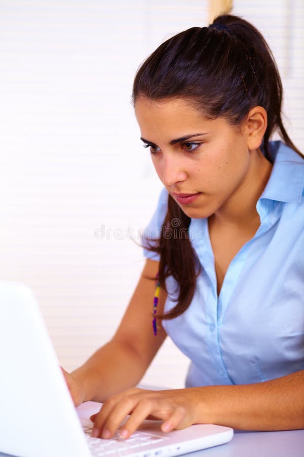 Giovane donna che per mezzo di un computer portatile immagini stock libere da diritti Giovane donna che per mezzo di un computer portatile immagini stock libere da diritti
