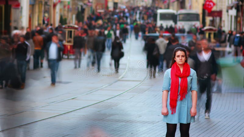 Giovane donna che posa, strada affollata, la gente che cammina intorno, 4K