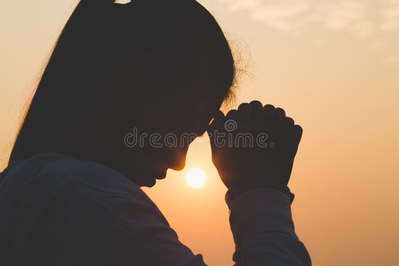 Giovane donna che pregano di mattina, mani piegate nel concetto di preghiera per fede, spiritualità e religione