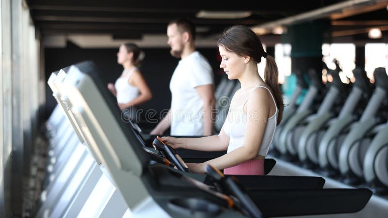 Giovane donna che si esercita su tapis roulant in palestra archivi video