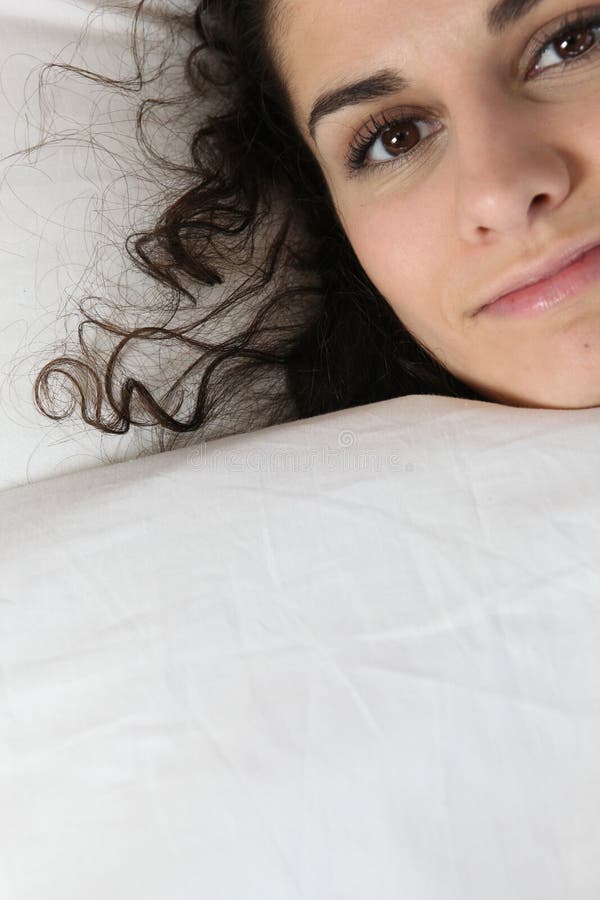 Giovane donna che si nasconde sotto il duvet fotografia stock libera da diritti Giovane donna che si nasconde sotto il duvet fotografia stock libera da diritti