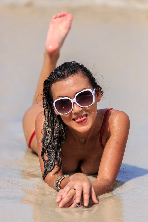 Giovane donna che si rilassa sulla spiaggia immagine stock
