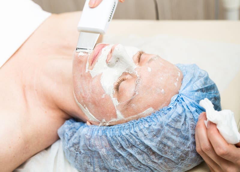 Giovane donna che si riposa in un salone della stazione termale e che ha una pulizia ultrasonica del fronte Le procedure cosmetic immagini stock Giovane donna che si riposa in un salone della stazione termale e che ha una pulizia ultrasonica del fronte Le procedure cosmetic immagini stock
