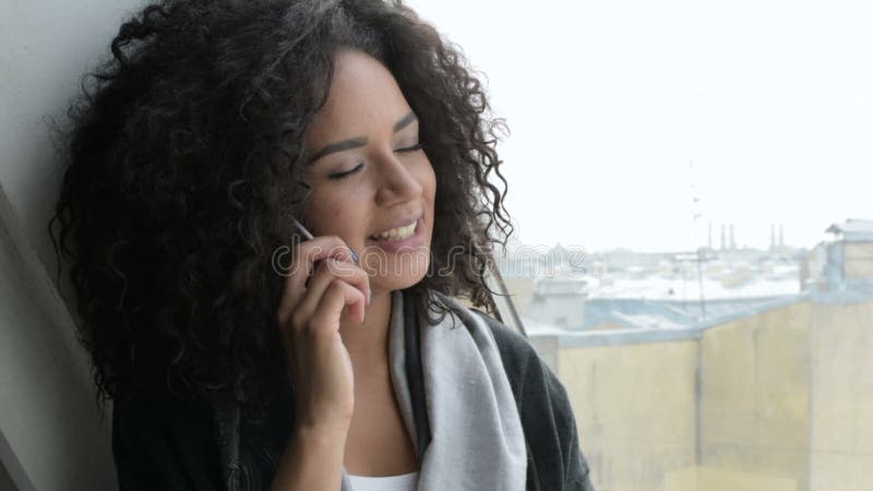 Giovane donna che si siede alla finestra