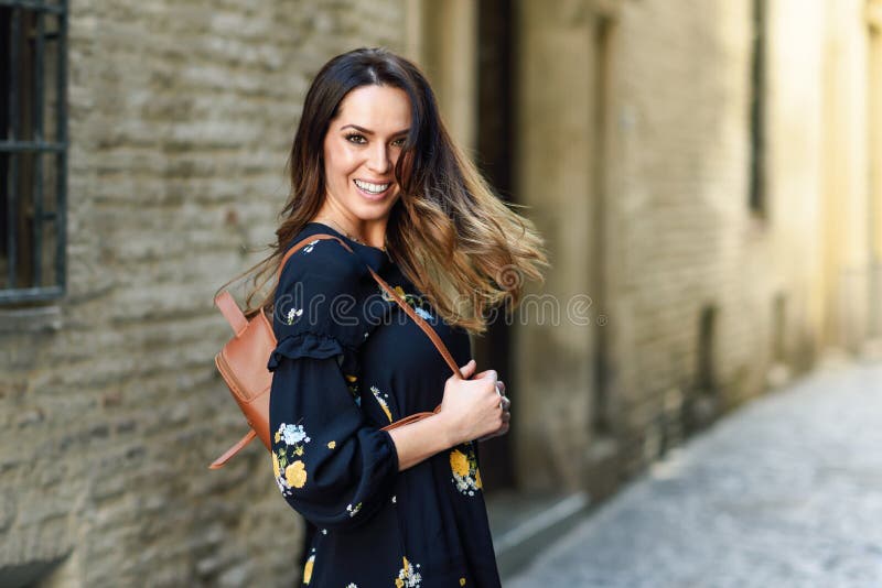 Giovane donna che si sposta i capelli lunghi su uno sfondo urbano immagine stock libera da diritti Giovane donna che si sposta i capelli lunghi su uno sfondo urbano immagine stock libera da diritti