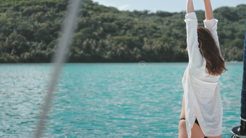Giovane donna che si sta rilassando a bordo di una barca a vela durante una vacanza nelle isole tropicali stock footage